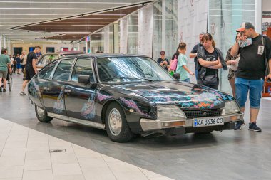 Pürüzsüz, açılı bir araba, kaputu açık, motor bölmesini gösteriyor. Araç kendine has stil özellikleri olan klasik bir model. Kyiv, Ukrayna 06-06-2024