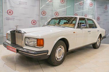 Lüks bir araba, muhtemelen eski bir Bentley ya da Rolls-Royce modeli, özelliklerini vurgulayan ve bitiren iyi ışıklandırılmış bir çevreye sahip bir galeride oturuyor, incl Kyiv, Ukrayna 06-2024