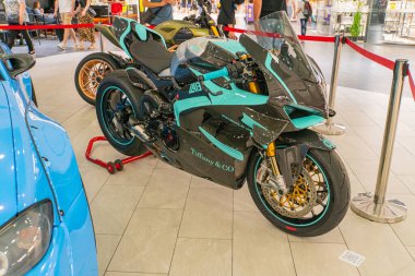 A sportbike with vibrant blue and teal color scheme sits on display in a showroom, showcasing aerodynamic bodywork with sharp angles typical of high-p Kyiv, Ukraine 06-06-2024 clipart