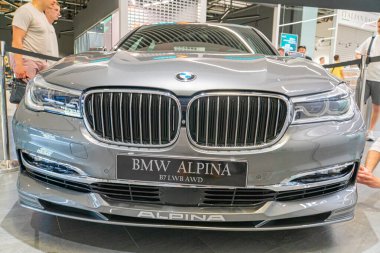 Çerçevenin sağ tarafına yerleştirilmiş gümüş renkli bir BMW Alpina B7 lüks sedan bir otomobil fuarında sergileniyor. Araç ön gril Kyiv, Ukrayna 06-06-2024