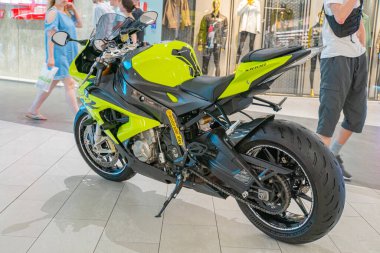 A sleek green and black sport motorcycle is displayed indoors at an angle, showcasing its front and side profile The motorcycle has a glossy finish a Kyiv, Ukraine 06-06-2024 clipart