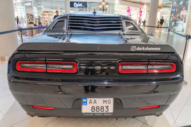 Arkadan siyah bir Dodge Charger sergileniyor, geniş gövdeli, parlak çamurlukları ve büyük tekerlekleri olan tasarımı sergileniyor. Araç feat Kyiv, Ukrayna 06-06-2024