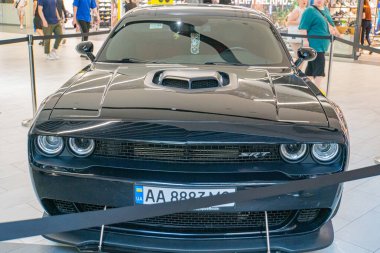 Muhtemelen Almanya 'dan gelen koyu renkli bir kaslı araba, bir otomobil fuarı veya sergisinde, Ukrayna 06-06-2024 Peo Kyiv, Ukrayna ile birlikte siyah kadife iplerle bir platformda sergileniyor.