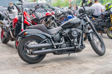 Üç motorsikletli bir hat kapalı bir garaja benzer bir ortamda park edilmiş, ortada siyah bir motosiklet, Ukrayna, Kyiv, 06-06-2024