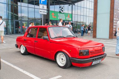 Geniş çamurlukları ve özel bir kaputu olan kırmızı bir araba, muhtemelen halka açık bir yerde park halinde. Araç, Ukrayna, 06-06-2024 'e ait.