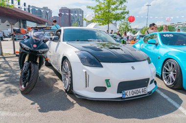 Otopark sahnesinde, spor motosiklet motosikleti Kyiv, Ukrayna 06-06-2024 'ün yanında duran aerodinamik kaportalı modifiye edilmiş bir spor araba da dahil olmak üzere çok sayıda araç yer alıyor.