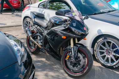 Yüksek gidonu ve aerodinamik kaplaması olan siyah bir motosiklet açık otoparkta görünür süspansiyon ayarlarıyla duruyor. Dr. Kyiv, Ukrayna 06-06-2024