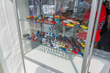 Model arabalarla dolu bir vitrin, cam kenarları ve kilit mekanizmasıyla halka açık bir alanda duruyor. Modeller çeşitli renkler sergiliyor, si Kyiv, Ukrayna 06-06-2024