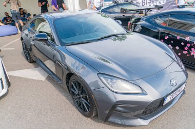 Gri spor bir araba kapalı bir otomobil fuarında, parlak tasarımı ve aerodinamik çizgileri yüksek performans kapasitesini vurguluyor. Araç fea Kyiv, Ukrayna 06-06-2024