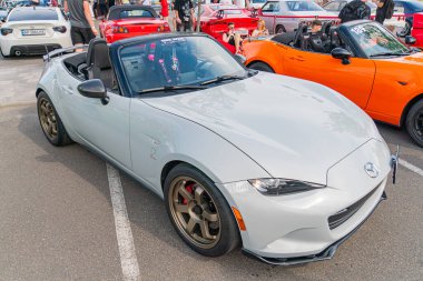 Gümüş renkli Mazda MX-5 Miata spor arabası asfalt bir yüzey üzerinde bir açıda durur, parlak kaplaması çevreyi yansıtır Küçük Mazda logosu Kyiv, Ukrayna 06-06-2024