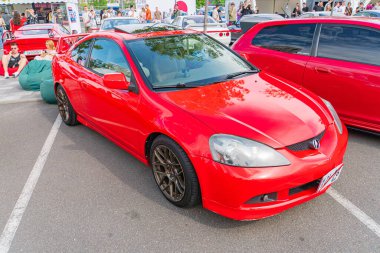 Kırmızı bir Honda Civic coupe, asfalt bir zemine park edilmiş, beyaz çizgiler de park alanlarını gösteriyor. Arabanın ön Kyiv, Ukrayna 06-06-2024 de dahil olmak üzere bir ceset kiti var.