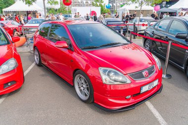 Kırmızı bir kompakt araba açık hava otoparkında, kameraya dönük, vücut kiti, yan etek ve arka Kyiv, Ukrayna 06-06-2024 gibi ayırt edici tasarım özellikleriyle park halinde.