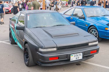 Koyu renk şeması, siyah ve deniz mavisi aksanlı modifiye edilmiş bir spor araba, piyasa tekerleri ve kaporta geliştirmeleri açık havada, Kyiv, Ukrayna 06-06-2024 ile çevrili.