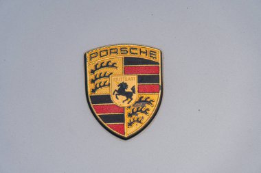 Porsche logosunun yakın plan görüntüsünde beyaz zemin üzerinde kırmızı ve siyah çizgili bir kalkan, Ukrayna, Kyiv, 06-06-2024 bayrağı taşıyan bir at yer alıyor.