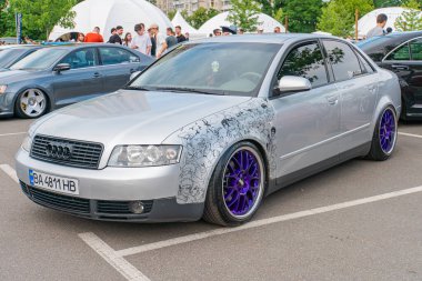 A modified silver compact sedan with aftermarket modifications, including a custom body kit, air intakes, rear wing spoiler, tinted windows, and lower Kyiv, Ukraine 06-06-2024 clipart