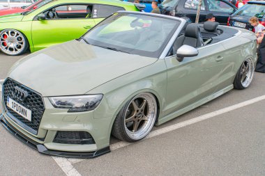 Üzerinde mat zeytin yeşili bir kaplama, geniş gövde kiti, özel hava girişleri ve havalandırmaları, büyük spoiler, Kyiv, Ukrayna 06-06-2024 bulunan asfalt üzerine park edilmiş modifiye edilmiş bir araba.