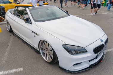 Yan yana çekilmiş beyaz bir BMW spor arabayı gösteren bir fotoğraf. Düşük bir duruş ve çok dilli tekerlekler içeren, Kyiv, Ukrayna 06-2024 profilli.