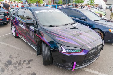 Özel yapım mor ve siyah boyalı modifiye edilmiş bir spor araba asfalt yüzeyine park edilmiş olup, bunlardan biri de aerodinamik Kyiv, Ukrayna 06-06-2024