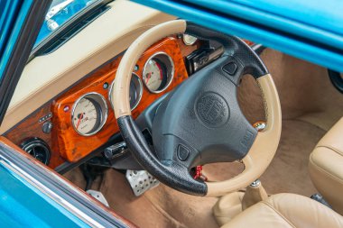 Görüntü, klasik bir araba sürücüsünün iç mekanını gösteriyor ve içlerinde hız, yakıt Kyiv, Ukrayna 06-06-2024 gibi birden fazla gösterge ve göstergelerin bulunduğu belirgin bir direksiyon simidi bulunuyor.