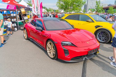 A red sports car is parked on a street, showcasing its sleek design and large alloy wheels with a distinctive multi-spoke pattern The vehicle has bra Kyiv, Ukraine 06-06-2024 clipart