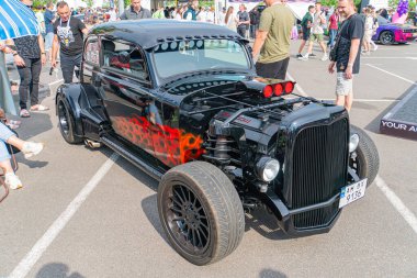 Alevleri andıran, kırmızı ve turuncu renkli siyah bir vücudun yer aldığı özenle hazırlanmış klasik bir araba, Ukrayna 'nın Kyiv kentinde, 06-06-2024' te park edilmiş durumda.