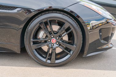 Bir arabanın yakın plan çekimi ön tekerlek siyah aksanlı çok dilli bir alaşım tasarımı ve muhtemelen spekülasyon Kyiv, Ukrayna 06-06-2024 'ten kırmızı bir amblem içerir.