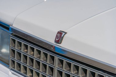 Birden fazla dikey levhası ve belirsiz amblemi olan klasik beyaz bir Amerikan otomobili, w Kyiv, Ukrayna 06-2024 açısında duruyor.