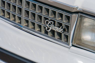 Dikey krom levhaları bulunan belirgin bir ızgara ile ön görünümde bir araç gösteriliyor ve GRAND kelimesi büyük, büyük harfli, büyük harflerle işlenmiş lett Kyiv, Ukrayna 06-2024