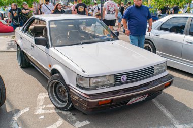 Pazar sonrası modifikasyonlara sahip beyaz bir hatchback arabası halka açık bir caddeye park edilmiş durumda, içinde bir ceset kiti, ön tampon spoiler ve Ukrayna, gi Kyiv, 06-06-2024 yan etekleri bulunuyor.