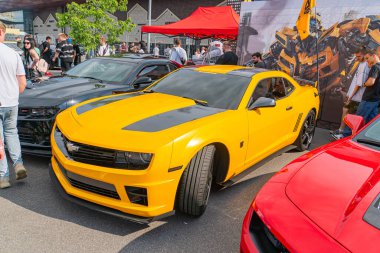 Siyah aksanlı sarı bir spor araba sahnenin ortasına park edilmiş, ön plandan orta sahaya kadar olan alanın çoğunu kaputu Kyiv 'e karşı, Ukrayna 06-06-2024