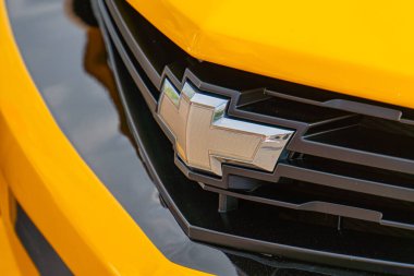 Sarı eski model bir aracın kaputu açık, kenarlarında çizikler ve pas var. Bir Chevrolet logosu Ukrayna, Kyiv, 06-06-2024 merkezinde belirgin bir şekilde sergileniyor.