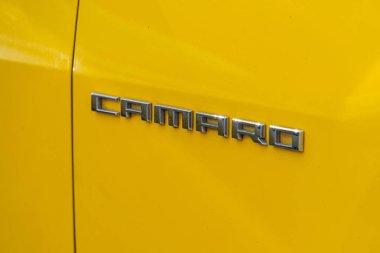 Sarı bir Camaro 'nun bagaj kapağının yakın plan görüntüsü büyük harfli CAMARO kabartmasını, parlak bir kapakla Lig Kyiv, Ukrayna 06-06-2024' ü yansıtıyor.