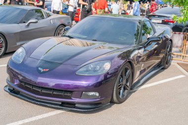 Pürüzsüz, modern bir spor araba açık havada bir etkinlikte ya da sergide park halindedir. Arabanın koyu mor parlak bir kaplaması ve Ukrayna, 06-06-2024 Kyiv, Ukrayna 'da kendine özgü hava girişleri vardır.