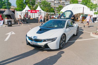 Beyaz bir BMW i8 spor arabası sergi salonunun zeminine park etmiş, ön taraftaki üç çeyrekten görünüyor kelebek kapıları kapalı, Kyiv, Ukrayna 06-06-2024