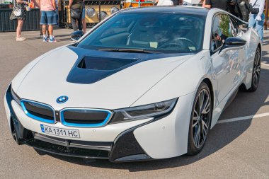 Pürüzsüz çizgileri ve aerodinamik eğrileri olan beyaz bir spor araba asfalt bir yüzeyde, büyük bir BMW ızgarası, LED farları ve çok dilli r Kyiv, Ukrayna 06-06-2024