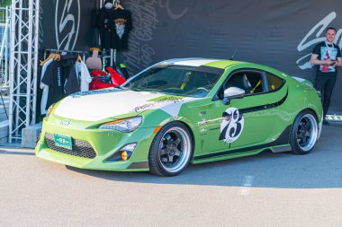 Yeşil bir Toyota Corolla yarış arabası yarış pistinde park halinde. Sponsor logoları Falken Lastikleri ve Eibach Springs sergileniyor. 97 numara Kyiv, Ukrayna 06-06-2024