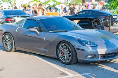 Koyu renkli bir Chevrolet Corvette, Ukrayna 06-06-2024 ön ve yan profili olan T Kyiv 'i göstermek için bir sokak olayının dörtte üçünde bir açıyla çekiliyor.