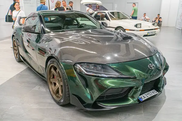 Pürüzsüz, koyu yeşil bir Aston Martin Vantage spor arabası diğer araçlarla çevrili bir otomobil fuarında sergileniyor, LED farlar, büyük bir g Kyiv, Ukrayna 06-06-2024