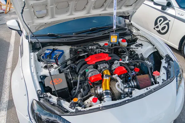 Kaputu açık olan beyaz bir arabanın motor bölümünün görüntüsü motoru ve hava emme sistemi, pil, Kyiv, Ukrayna 06-06-2024 gibi çeşitli bileşenleri gözler önüne seriyor.