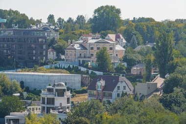 Büyüleyici bir Avrupa köyü bir tepenin yamacında, kırmızılar, sarılar ve maviler de dahil olmak üzere çeşitli renklere boyanmış binalar var. Kyiv, Ukrayna 06-06-2024