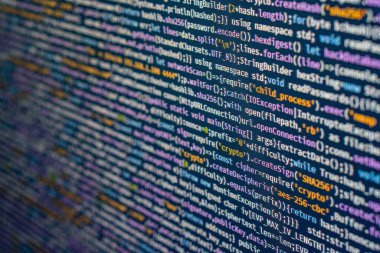 Ekrandaki renkli bilgisayar kodunun yakın görüntüsü, ifadelerin koyu bir arkaplanda sığ bir alan derinliğinde dönüp dönmediğini gösterir