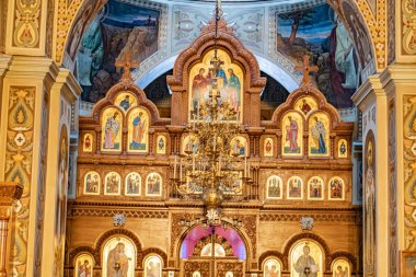 Image depicts a grand Eastern Orthodox church or chapel interior, featuring an elaborate altar, numerous icons in golden frames, detailed artwork, and opulent decorations Kyiv, Ukraine 01-14-2024