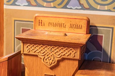 Tahta bir sandık, muhtemelen çiçeklerle süslenmiş, fayanslarla döşenmiş bir duvara dayanıyor sandık Yunan yazıtlarını taşıyor Yargıç geldi fotoğraf Kyiv, Ukrayna 01-14-2024