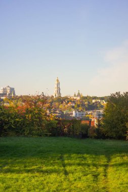 Gökyüzünden şehir manzarasına geçiş gösteren birleşik bir manzara, sonbahar yaprakları sergilenen ağaçlar ve iyi manikürlü bir çimenlik hem doğal hem de u manzaralı bir yerden çekilmiş.