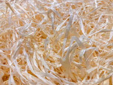 Görüntü parçalanmış materyalin yakın plan görüntüsü, muhtemelen kağıt lifler uzun ve çeşitli yönlere yöneliktir arka plan katı bir renk, ana özne içindeki dokuyu vurguluyor.