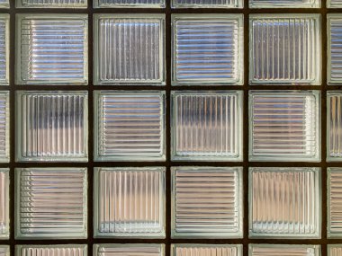 Resim, eşit aralıklı fayanslara sahip aydınlık, şeffaf bir fayans duvarının yakın görüntüsünü gösterir