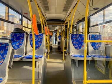 Yerleşik yolcu perspektifinden çekilen bir şehir otobüsünün görüntüsü koltuklar desenli dizaynlarla mavi döşemelere sahiptir ve Kyiv, Ukrayna, 03-15-2024 sırasına göre dizilmiştir.