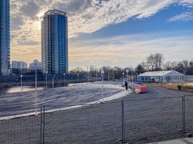 Dışarıdaki bir inşaat alanında faili meçhul, çakıllı bir alan inşaat halinde büyük bir bina ve etrafa dağılmış bir pelerin Kyiv, Ukrayna, 03-15-2024 ile yakınlarda bir başka yüksek bina.