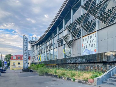 Güneş panelleri veya gölgelendirme elementleri, yağmur suyu hasat özellikleri ve sokak sanatı olan modern, çevre dostu bir şehir binasının samimi bir fotoğrafı. Ön cephede küçük bir Kyiv, Ukrayna, 06-15-2024