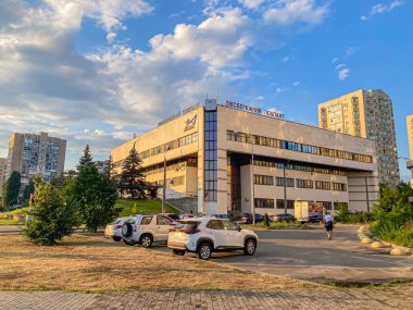 Modern, çok katlı ticari ofis binası, park arabaları, yeşillik, mavi gökyüzü ve dağınık bulutlar Kyiv, Ukrayna, 06-15-2024
